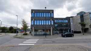 Kontorbygg med blå vinduer og moderne arkitektur.