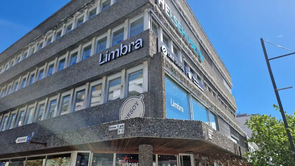 Limbra klinikkbygning med tydelig skilt og store vinduer i sentrum av byen.