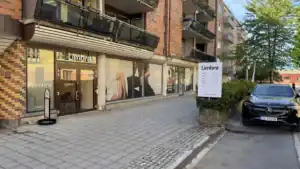 Utenfor Limbras klinikk med skilt og inngang, omgitt av trær og parkeringsplass.