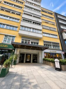 Leilighetsbygg med flere etasjer og store vinduer i urbant område.
