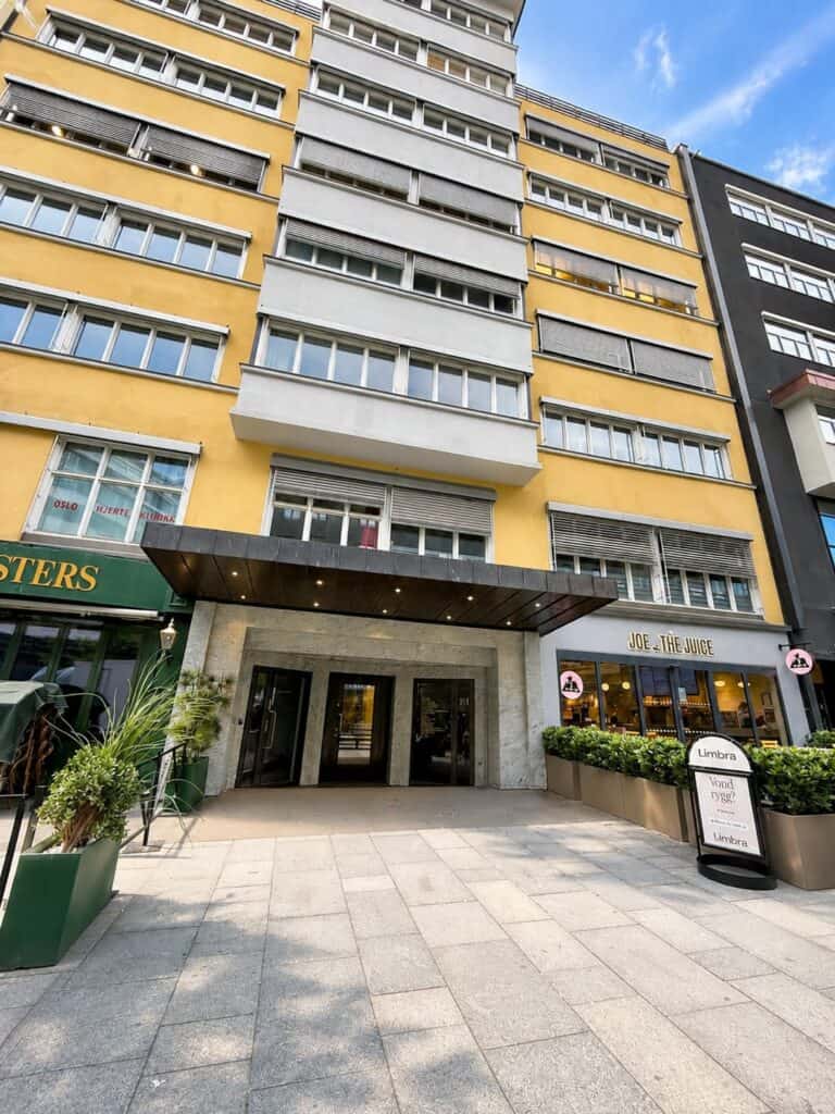 Leilighetsbygg med flere etasjer og store vinduer i urbant område.