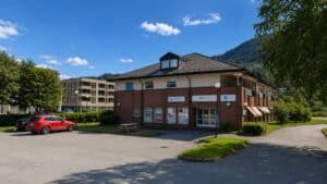 Moderne klinikkbygning i naturskjønne omgivelser med parkering.