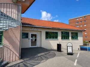 Utendørs bilde av Limbra klinikk med inngang og skilt, klar for pasientbesøk.