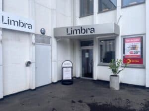 Limbra klinikkens inngang med skilt og plante utenfor.