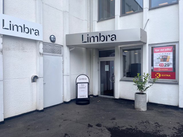 Limbra klinikkens inngang med skilt og plante utenfor.