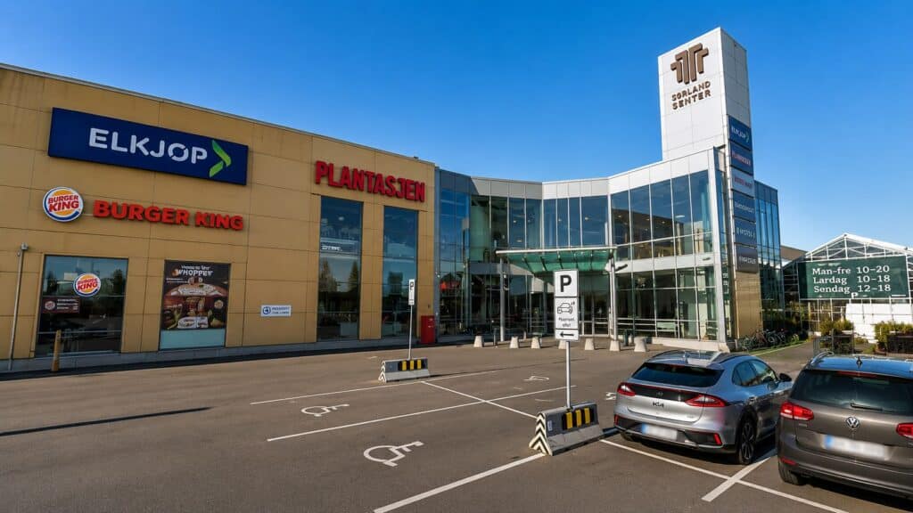 Handelsenter med butikker som Elkjøp, Burger King og Plantasjen, samt parkeringsplasser foran inngan.
