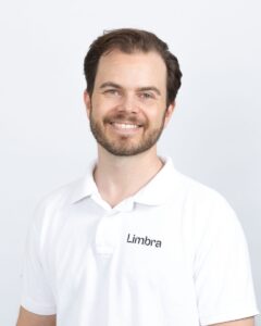 Kiropraktor Aleksander Kjærnsmo fra Limbra med hvit polo og smil.