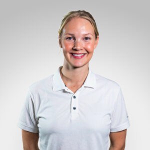Smilende kvinne i hvit polo, portrett.