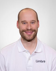 Kiropraktor fra Limbra smilende foran hvit bakgrunn.