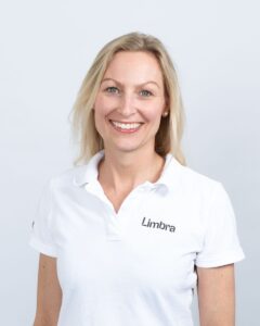 Anette Tryti, profesjonell kiropraktor med smilende ansikt, i hvit Limora-polo.