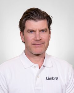 Kiropraktor fra Limbra med hvit polo, ser direkte inn i kameraet.