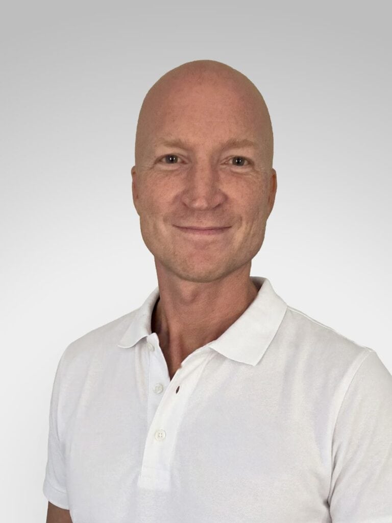 Kvinne med hvit polo smilende mot kamera, portrett.