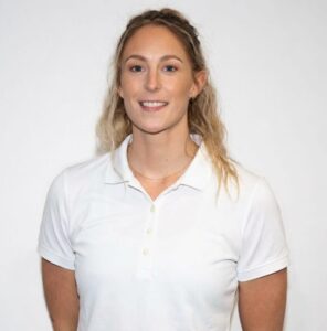 Kvinne smilende i hvit polo, portrett mot hvit bakgrunn.