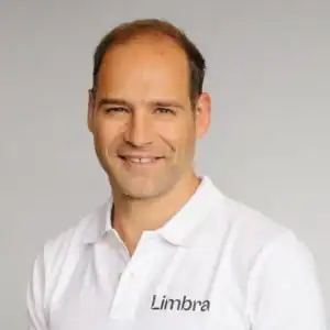 Kiropraktor Daniel Pollard smiler i hvit klinikkuniform.