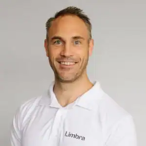 Kiropraktor Eirik Larsen smiler i hvit klinikkuniform.