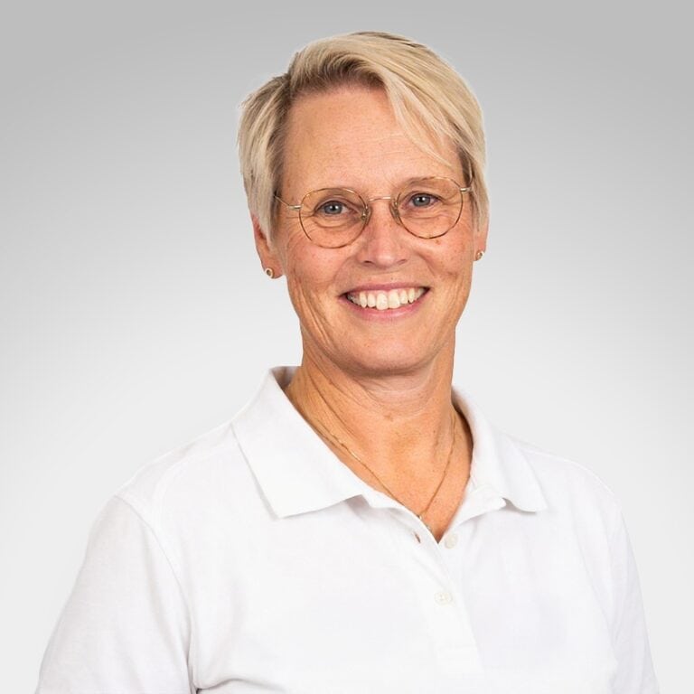 Grete K. Bråten, kiropraktor ved Limbra, smilende i hvit skjorte.