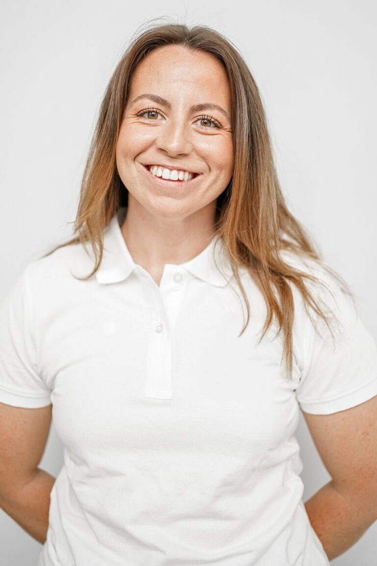 Smilende kvinne i hvit polo-shirt, portrett, nærbilde.