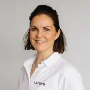 Kvinne i hvit arbeidsuniform med Limbra-logo.