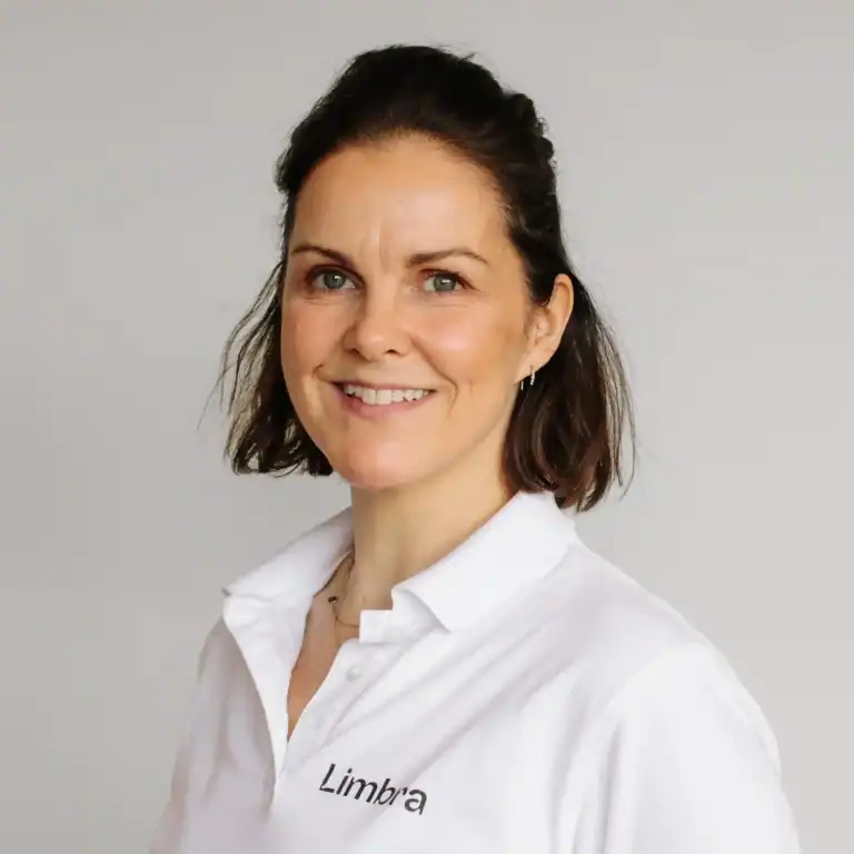Kvinne i hvit arbeidsuniform med Limbra-logo.