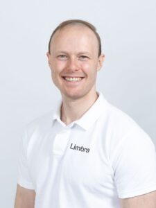 Jørgen Hangeraas, kiropraktor ved Limbra, smilende foran hvit bakgrunn.