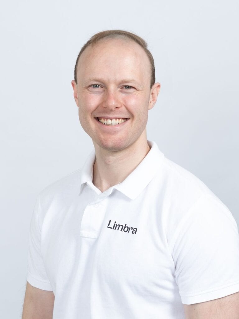 Jørgen Hangeraas, kiropraktor ved Limbra, smilende foran hvit bakgrunn.