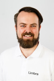 Kiropraktor med hvit skjorte og smilende ansikt.