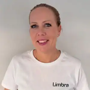 Kvinne smilende i Limbra T-skjorte mot lys bakgrunn.