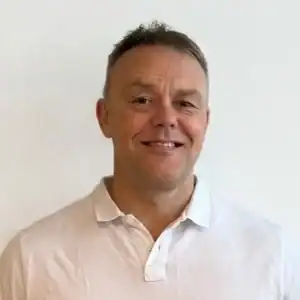 Portrett av Kjetil Syvertsen smilende i hvit skjorte.