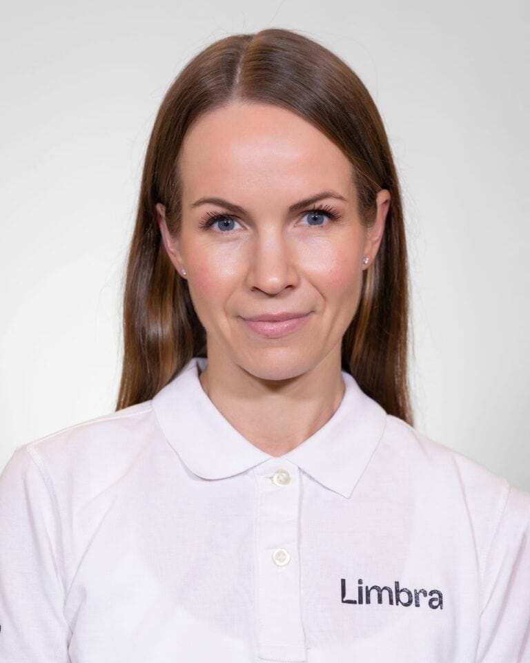 Kvinne i hvit Limba-uniform smilende mot kamera.