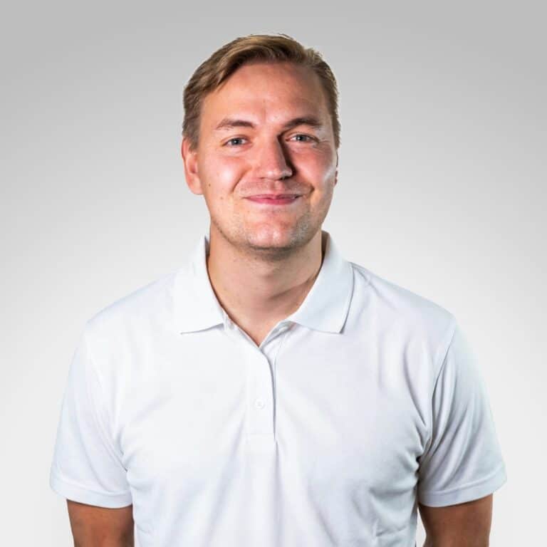 Lasse Grøn smilende i hvit polo, portrett for helse- og velværeklinikken Limbra.