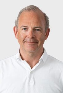Leif Gustav Pedersen, profesjonell mann i hvit skjorte, smilende, portrettbilde.