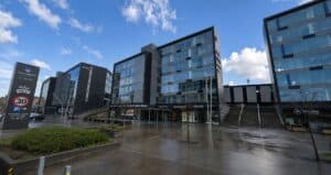 Moderne kontorbygg i sentrum med glassfasade og parkeringsmuligheter.