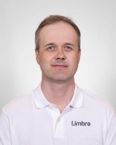 Kiropraktor i hvit skjorte med Limbra-logo, nærbilde.