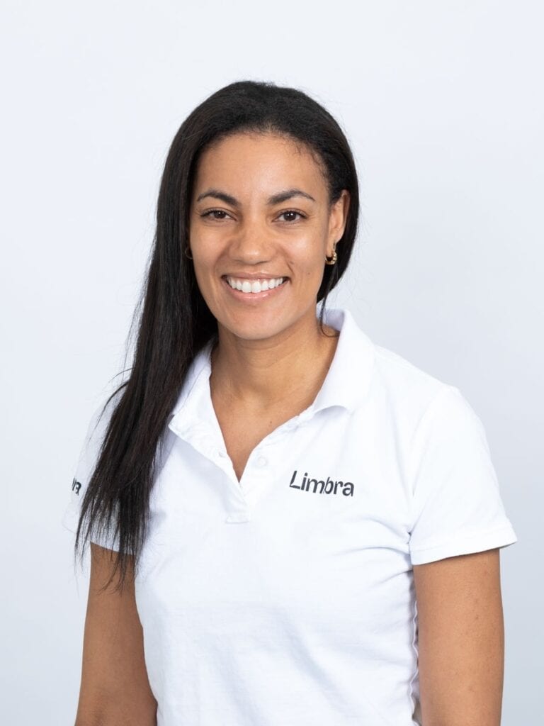 Limbra kiropraktor Monica Beharie smilende i hvit uniform.