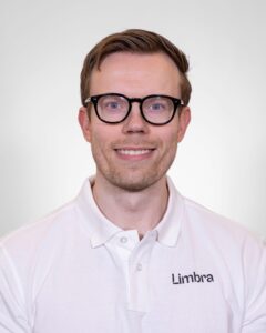Robert Ørevik, kiropraktor ved Limbra, smilende foran hvit bakgrunn.