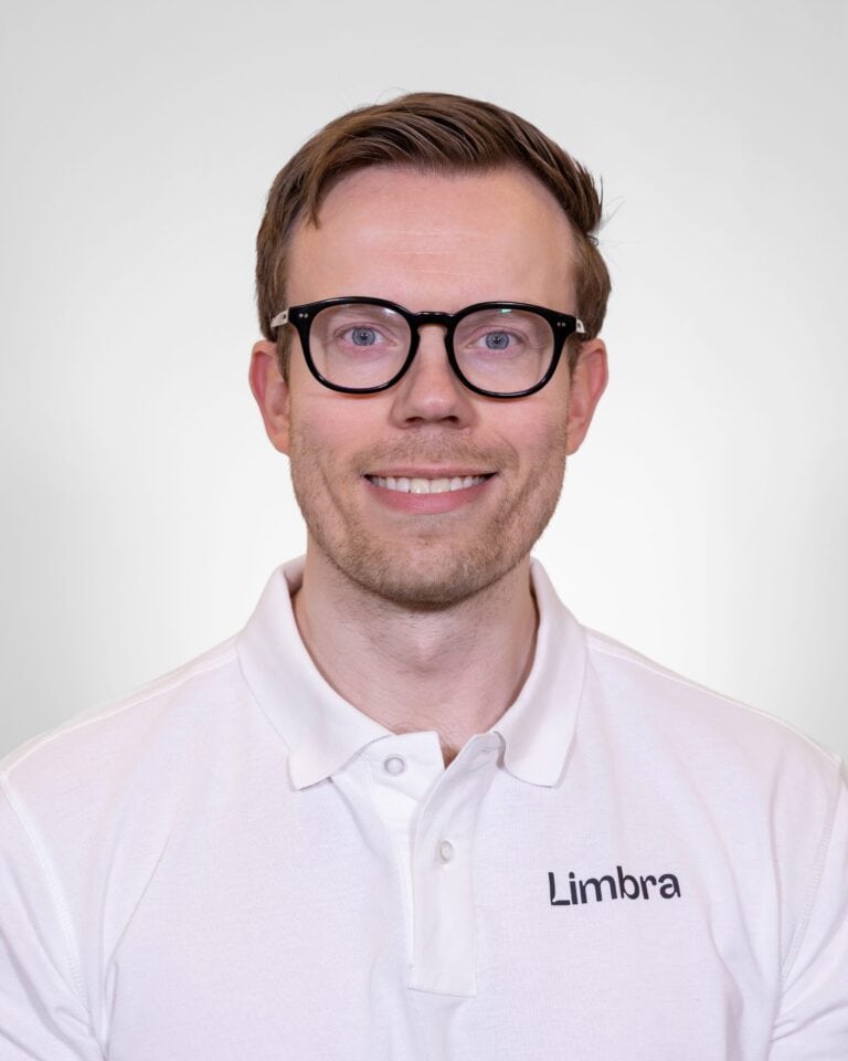 Robert Ørevik, kiropraktor ved Limbra, smilende foran hvit bakgrunn.