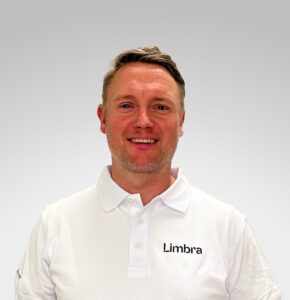 Kiropraktor fra Limbra smilende i hvit arbeidsuniform.