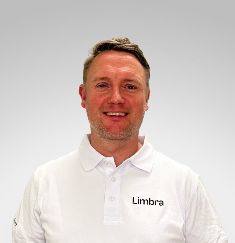 Kiropraktor fra Limbra smilende i hvit arbeidsuniform.