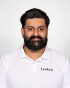 Kiropraktor med Limbra-logo, smilende mann i hvit skjorte.
