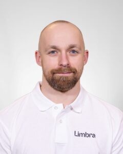 Kiropraktor fra Limbra smilende foran hvit bakgrunn.