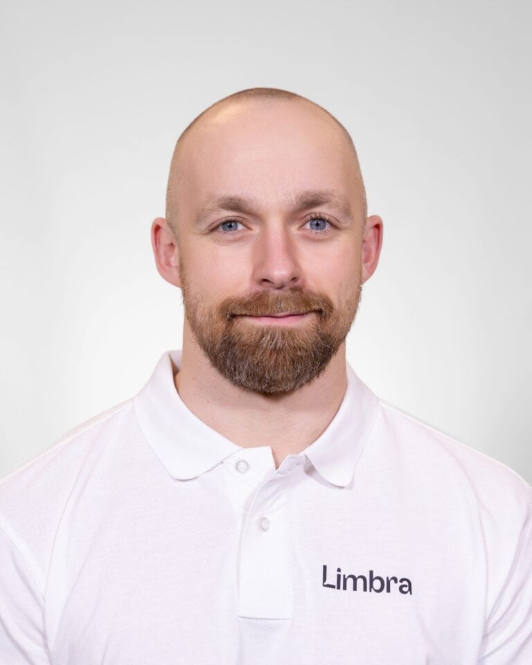 Kiropraktor fra Limbra smilende foran hvit bakgrunn.