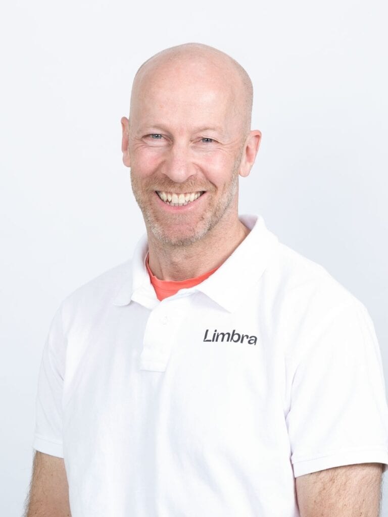 Limbra kiropraktor Thomas Lauvsnes smilende i hvit klinikkuniform.