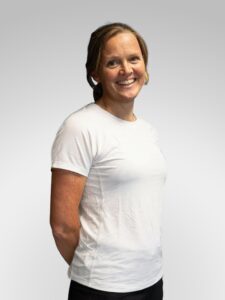 Kvinne smilende i hvit t-skjorte, portrett.