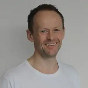 Portrett av Trond Viste med smil, hvit bakgrunn.