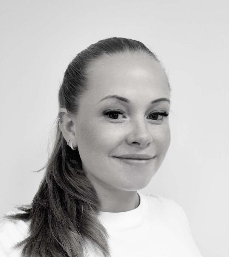 Kvinne smilende, portrettbilde i svart-hvitt, profesjonell og vennlig.