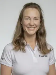 Kvinne i hvit Limba-polo smiler mot kamera.