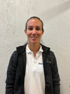 Marit Slåtten, kiropraktor ved Limra, smilende foran en lys vegg.