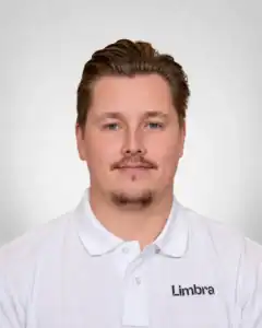 Kvinne i hvit Limbraklær med logo, smilende mot kamera.