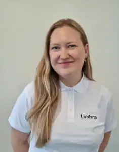 Ansatt i Limbras uniform smilende mot kamera.