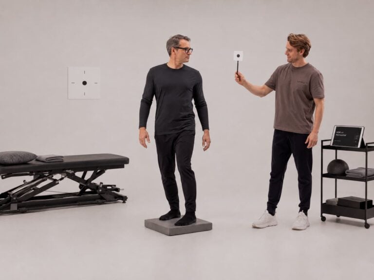 Kiropraktiker utfører undersøkelse med måleinstrument i klinikkmiljø.